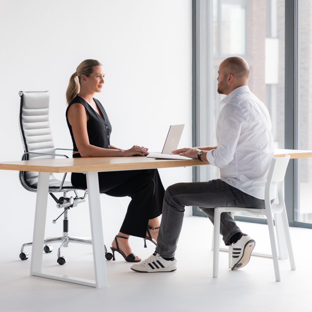Steuerberatung im Gespräch – zwei Personen an einem Tisch mit Laptop