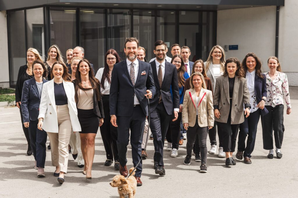 Gesamtes Team der Steuerberatung L-Quadrat im Freien mit Bürohund