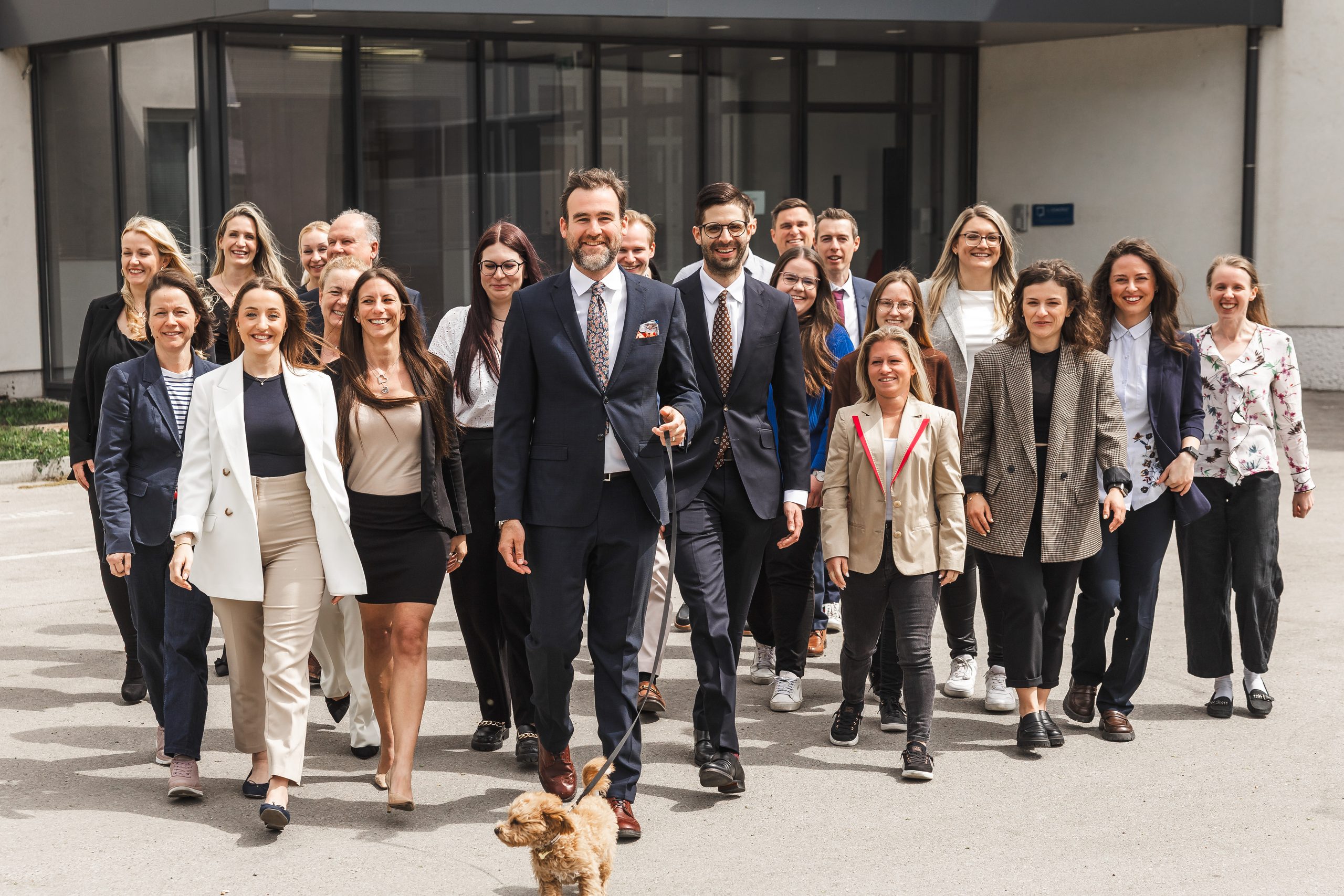 Gesamtes Team der Steuerberatung L-Quadrat im Freien mit Bürohund